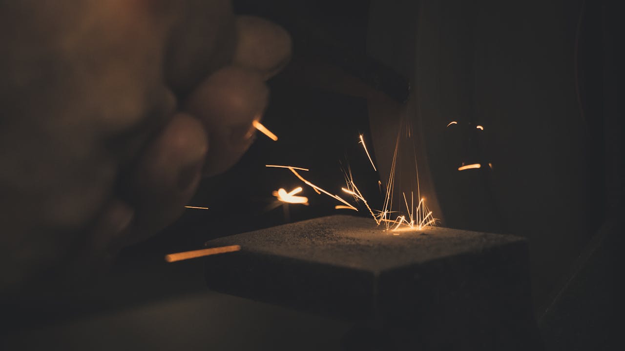 Dramatic long exposure of sparks flying during metalwork, highlighting craftsmanship.